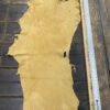Tanned leather hide on wooden surface.
