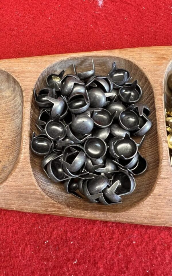 Black metal rings in a wooden tray.