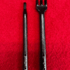 Two black leathercraft tools on red background.