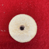 Beige round felt pad on red surface.