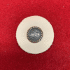 Decorative button on red fabric background.