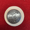 Decorative metal button on red fabric.