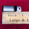 Metal clip next to wooden ruler.