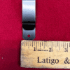 Metal clip and ruler on red background.