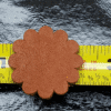 Brown leather flower on measuring tape.