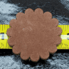 Brown leather flower on yellow measuring tape.