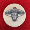 Silver skull badge with sombrero on red.