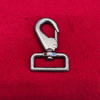 Metal clasp hook on red background.