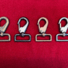 Four metal hooks on a red background.