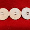 Three round felt discs on red background.