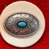 Silver belt buckle with turquoise stone.