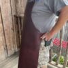 IMG_9364 Person wearing a brown leather apron outdoors.