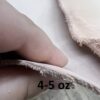 Hand holding leather piece, labeled 4-5 oz.
