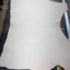 Large piece of light-colored leather on table.