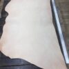 Leather hide on wooden table with ruler.