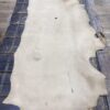 Tanned leather hide on wooden surface.
