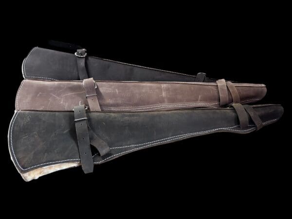 Three leather rifle scabbards stacked.