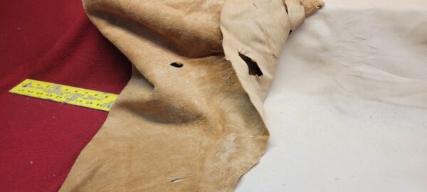 Torn leather pieces with measuring tape.