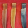 Three knife sheaths on a red surface