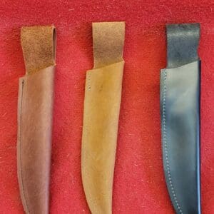 Three knife sheaths on a red surface