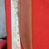 Knife in leather sheath beside measuring ruler.