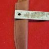 Leather knife sheath with measuring tape.