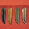 Four knife sheaths on a red surface