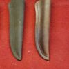 Two leather knife sheaths on red background.