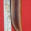Leather knife sheath next to measuring ruler.
