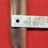Leather sheath measured with a ruler.