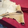 20231221_143843 Beige leather hide on red fabric.
