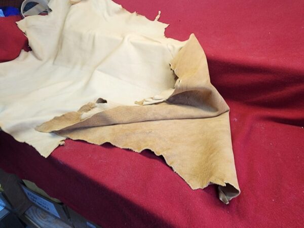 20231221_143843 Beige leather hide on red fabric.