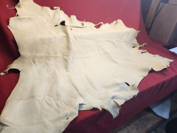 Tan leather hide on a red surface.
