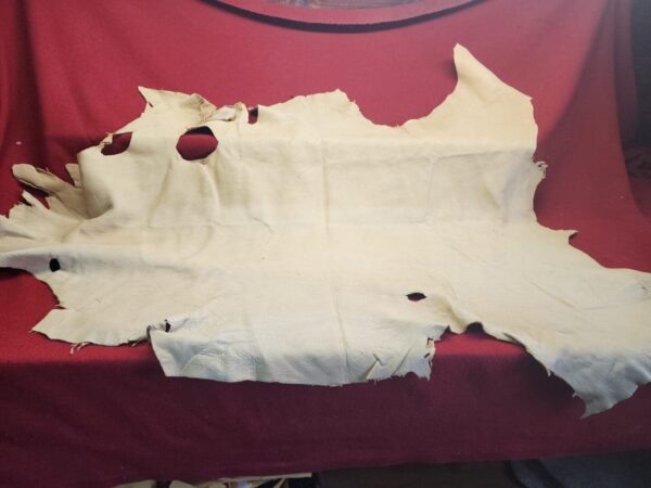 Worn leather hide on red fabric background.