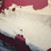 Tanned animal hide on a red surface.
