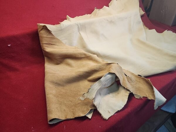 Leather pieces on a red fabric background.