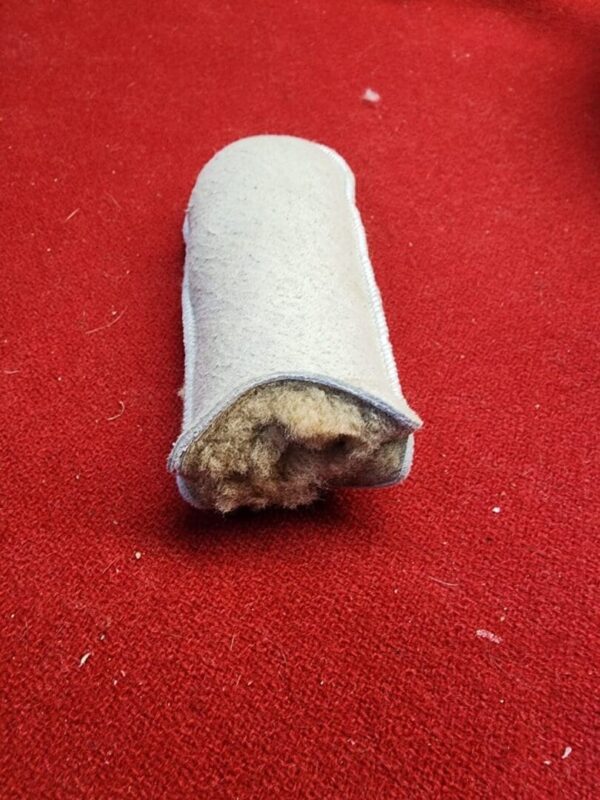 White fur-lined tube on red surface.