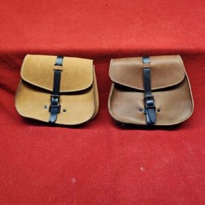 20231221_184030 Two leather satchels on a red background.