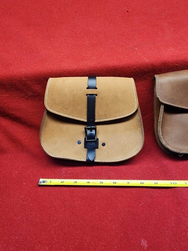 Leather pouch with buckle on red fabric.