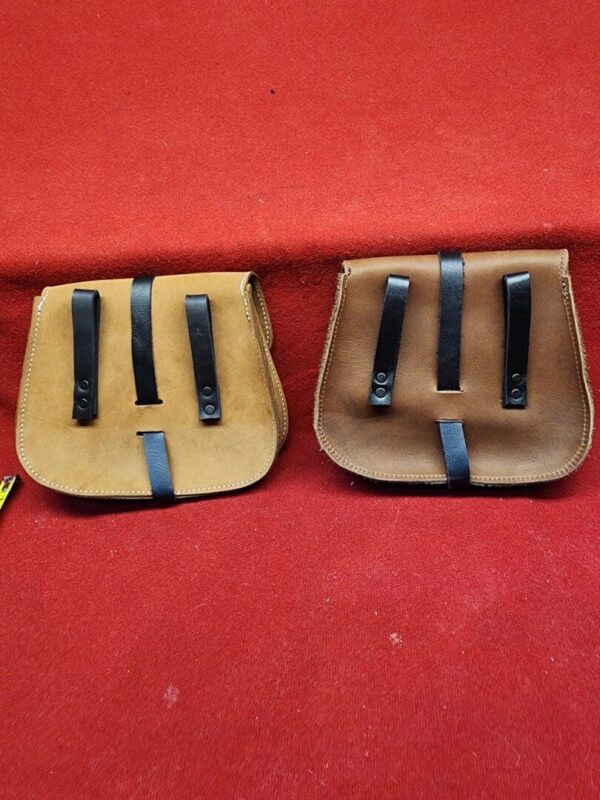 Two brown leather saddlebags on red background.