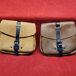 20231221_184204 Two leather pouches on red fabric.