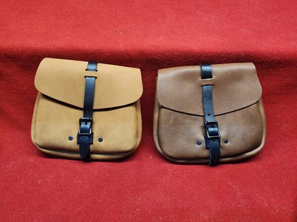 20231221_184204 Two leather pouches on red fabric.