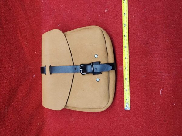 20231221_184230 Tan pouch with black strap, red background.