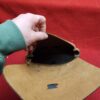 20231221_184256 Hand holding open a leather pouch.