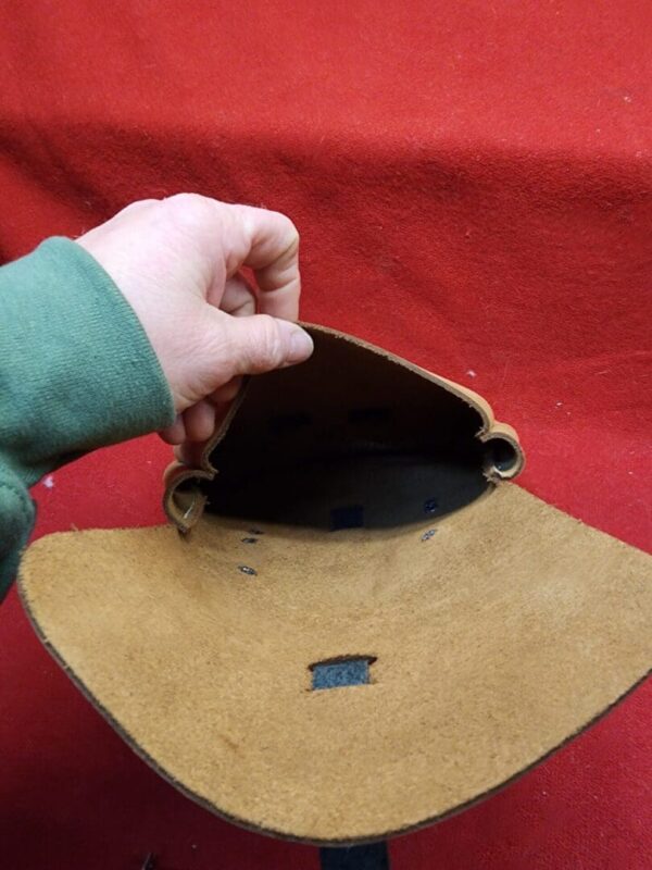 20231221_184256 Hand holding open a leather pouch.