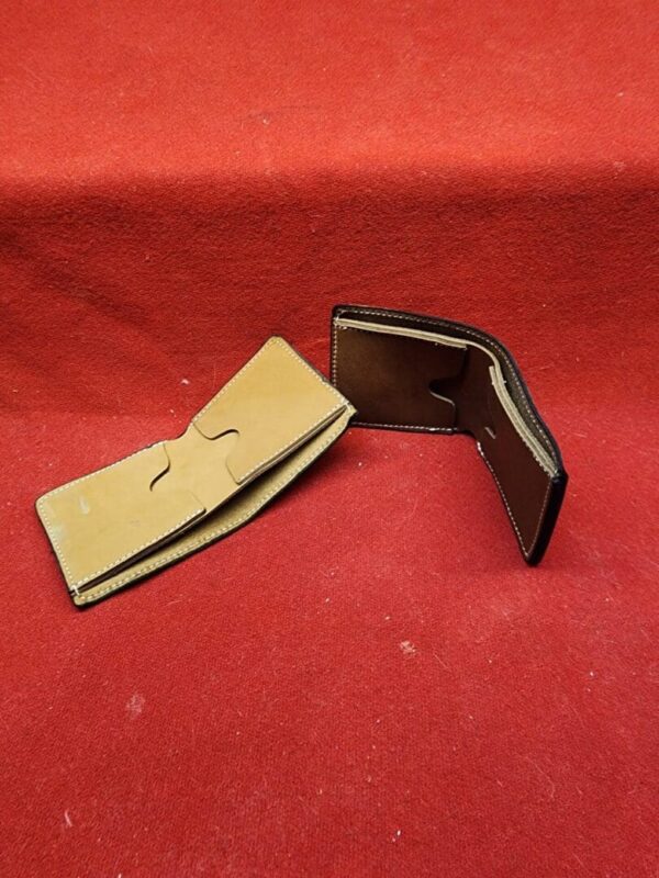 20231221_184342 Two leather wallets on red surface.