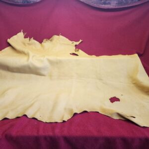 20231222_114011 Yellow leather hide on red fabric background.