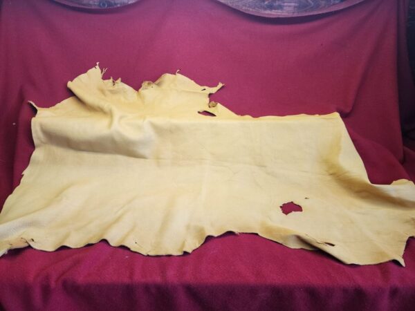 Yellow leather hide on red fabric background.