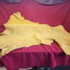 Yellow leather hide on red fabric background.