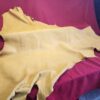 Yellow leather hide on red fabric background.